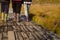 People in boots walk along a wooden path in a swamp in Yelnya, Belarus