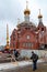 People bypass the fallen fence enclosing the construction of an Orthodox church
