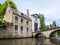 People on canal bridge and entrance gate to Begijnhof, Beguinage, in Bruges, Belgium