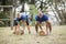 People carrying heavy wooden logs during obstacle course