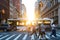 People, cars, bikes and buses traveling through a busy intersection on 5th Avenue and 23rd Street in New York City with shining