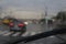 People and cars cross the street in the rain, traffic on the street