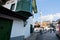 People and cars move on the narrow street with mosque and old Ottoman style house