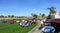 People at charity car show admiring rows of classic, hot rod and special interest cars parked at a golf course in Palm Springs