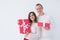 People, christmas, birthday, holidays and valentine`s day concept - happy young man and woman with gift boxes on white