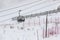 People climbing a cable car downhill in a snowfall