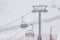 People climbing a cable car downhill in a snowfall