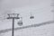 People climbing a cable car downhill in a snowfall