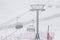 People climbing a cable car downhill in a snowfall