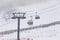 People climbing a cable car downhill in a snowfall