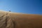 People Climbing Down Desert Dune into Sossusvlei Salt Pan