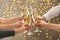 People clinking glasses with champagne against blurred lights. Bokeh effect