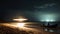 people on the coast sit on the sand and look at the UFO. an alien ship hovers over the beach at night, emitting a bright light.