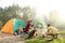 People cooking on bonfire near camping tent