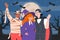 People in costumes for Halloween night, vampire, witch and mummy against the background of a night landscape and a full moon