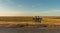 People couple sit on a bench in the middle of nowhere. Flat, remote, peaceful, meadow landscape