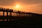 People crossing the longest teak bridge in the world, the iconic wooden U Bein Bridge during sunset, Mandalay, Myanmar