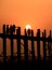 People crossing the longest teak bridge in the world, the iconic wooden U Bein Bridge during sunset, Mandalay, Myanmar