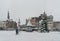 People crossing the snow covered Markt with in the center a christmas tree in the center of Den Bosch.