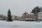 People crossing the snow covered Markt with in the center a christmas tree in the center of Den Bosch.