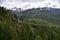 People crossing a Suspension Bridge with view of snow capped Sky Pilot Mountain