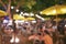 People crowd in night party festival of outdoor garden with light bulb hanging decoration, image blur