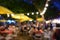 People crowd in night party festival of outdoor garden with light bulb hanging decoration, image blur used for celebration