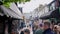 People crowd and tourists walking down the narrow streets of Brighton visiting small shops.