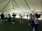 People dance outdoor under a tent during Ecstatic meditation dancing class