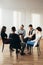 People of different ages sits in a circle during a meeting with a professional therapist