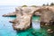 People diving from the flat cliff, sunbathing, swimming in crystal clear sea water on the rocky beach Torre Sant Andrea with rocks