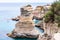 People diving from the flat cliff, sunbathing, swimming in crystal clear sea water on the rocky beach Torre Sant Andrea with rocks