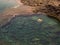 people diving in a natural basin in the rocks coastline of Lanzarote