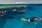 People diving at open clear blue sea reef