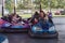 People on dodgem bumper car ride at amusement fair