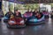 People on dodgem bumper car ride at amusement fair