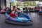 People on dodgem bumper car ride at amusement fair