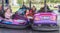 People on dodgem bumper car ride at amusement fair