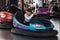 People on dodgem bumper car ride at amusement fair smiling and having fun