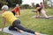 People doing yoga class while keeping social distance at city park - Focus on left senior face