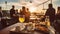 People eating cheese and drinking wine at rooftop restaurant at sunset time. Restaurant table served with cheese plate, bread and