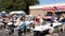 People eating at tables in a parking lot during community fair