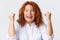 People, emotions and lifestyle concept. Close-up of lucky winning middle-aged redhead woman celebrating victory, looking
