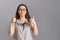 People and emotions. A young brunette in a blouse and glasses shows her thumbs up with both hands. Copy space