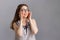 People and emotions. A young brunette in a blouse holds onto her glasses and looks joyfully to the side. Copy space