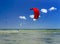 People engaged in kitesurfing on a summer day in a sea