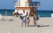 People enjoy the beach next to a lifeguard tower