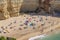 People enjoy the scenic beach at the Algarve coast near Carvoeiro and follow the rules for tourists at the beach according Corona