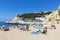 People enjoy the scenic beach at the Algarve coast near Carvoeiro and follow the rules for tourists at the beach according Corona