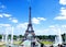 People enjoy sunshine and fountain pool in front of the Eiffel Tower